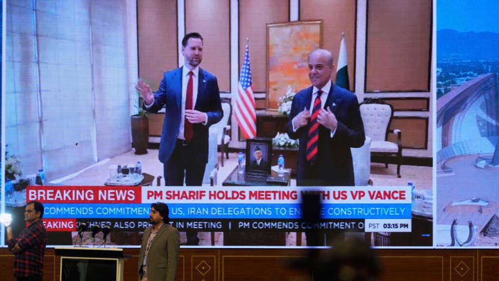 Journalisten arbeiten, während das pakistanische Staatsfernsehen das Treffen zwischen US-Vizepräsident J.D. Vance und dem pakistanischen Premierminister Shehbaz Sharif in einem Medienzentrum für die Berichterstattung über die US-Iran-Gespräche in Islamabad überträgt. Foto: Anjum Naveed/AP/dpa