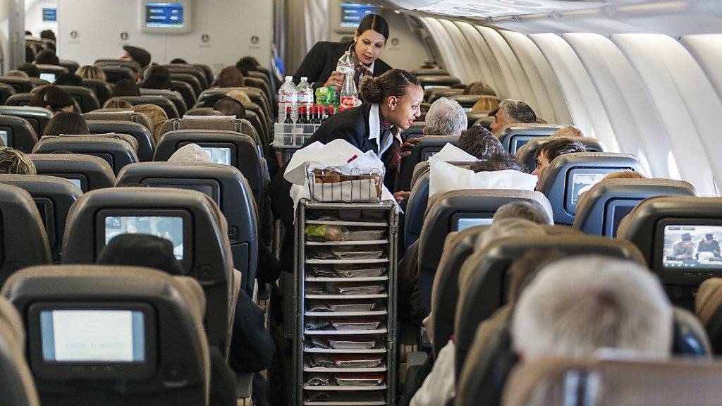 Zwei Flugbegleiterinnen bedienen in einem gut gefüllten Swiss-Flugzeug Passagiere der Economy Class. In den ersten neun Monaten des Jahres hat die Fluggesellschaft mehr Passagiere angezogen als noch im Vorjahr. (Archiv)
