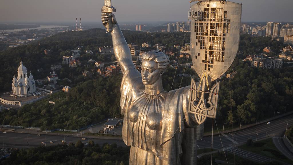 Arbeiter montieren das ukrainische Wappen auf das Schild der Mutter-Heimat-Statue. Foto: Efrem Lukatsky/AP/dpa