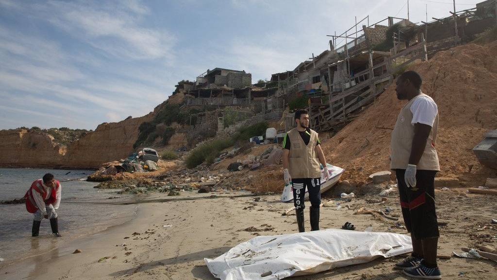 Mitarbeiter des Roten Kreuzes bedecken eine Leiche an einem Strand östlich von Tripoli, Lybien. (AP Photo/Mohamed Ben Khalifa/KEYSTONE)