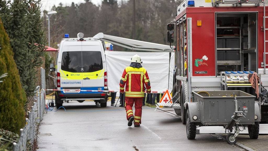 Ein Feuerwehrmann unterwegs auf der Lenzhardstrasse in Rupperswil AG, wo in einem Haus vier Tote gefunden wurden.(KEYSTONE/Patrick B. Kraemer)
