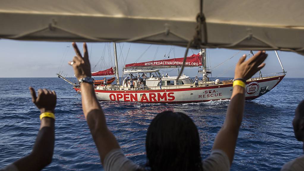 ARCHIV - Migranten winken an Deck des Rettungsschiffs «Open Arms», das sich dem Hafen von Barcelona nähert. Foto: Olmo Calvo/AP/dpa
