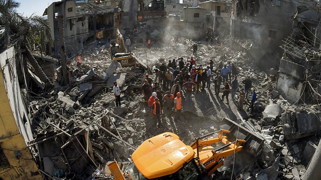 Mitarbeiter des libanesischen Zivilschutzes versammeln sich an dem Ort, der von israelischen Luftangriffen in einem bewohnten Gebiet und nicht weit vom wichtigsten öffentlichen Krankenhaus betroffen war. Foto: Stringer/dpa