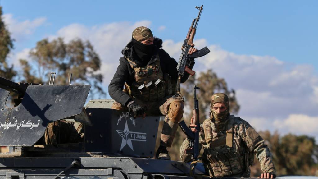 Soldaten der kurdisch geführten und von den USA unterstützten Syrischen Demokratischen Kräfte (SDF) sichern mit gepanzerten Militärfahrzeugen Straßen, die zum Gweiran-Gefängnis führen, in dem Männer untergebracht sind, die beschuldigt werden, Kämpfer des Islamischen Staates (ISIS) zu sein. Foto: Baderkhan Ahmad/AP/dpa