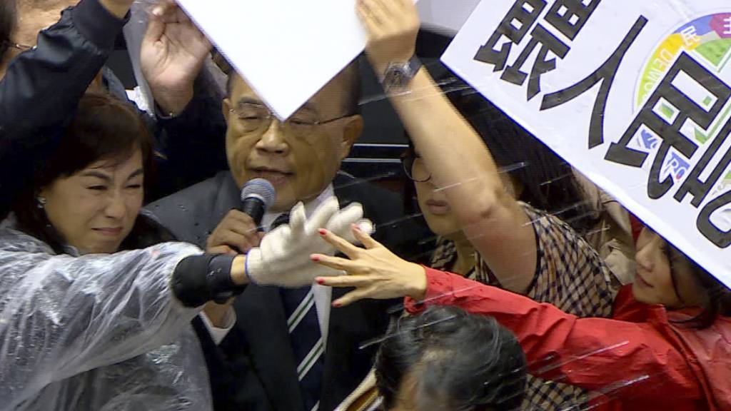 SCREENSHOT - Ministerpräsident Su Tseng-chang wird im Parlament mit Schweineinnereien beworfen. Foto: -/FTV/AP/dpa