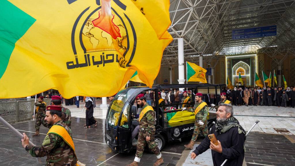 Mitglieder der Kataib Hisbollah nehmen an der Beerdigung von Kämpfern teil, die nach eigenen Angaben bei einem US-Luftangriff in der Provinz Qaim getötet wurden. Foto: Anmar Khalil/AP/dpa