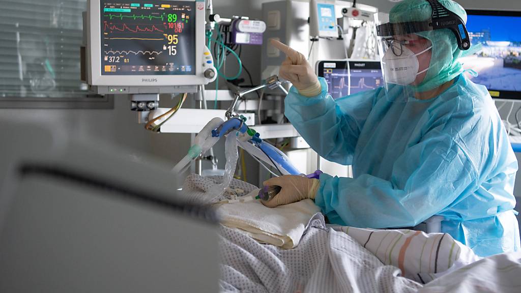 dpatopbilder - PRODUKTION - Eine Intensiv-Pflegerin versorgt einen schwer an Corona erkrankten Patienten auf der Intensivstation des Klinikums in Fulda. Rund die Hälfte der künstlich beatmeten Patienten stirbt. Foto: Boris Roessler/dpa