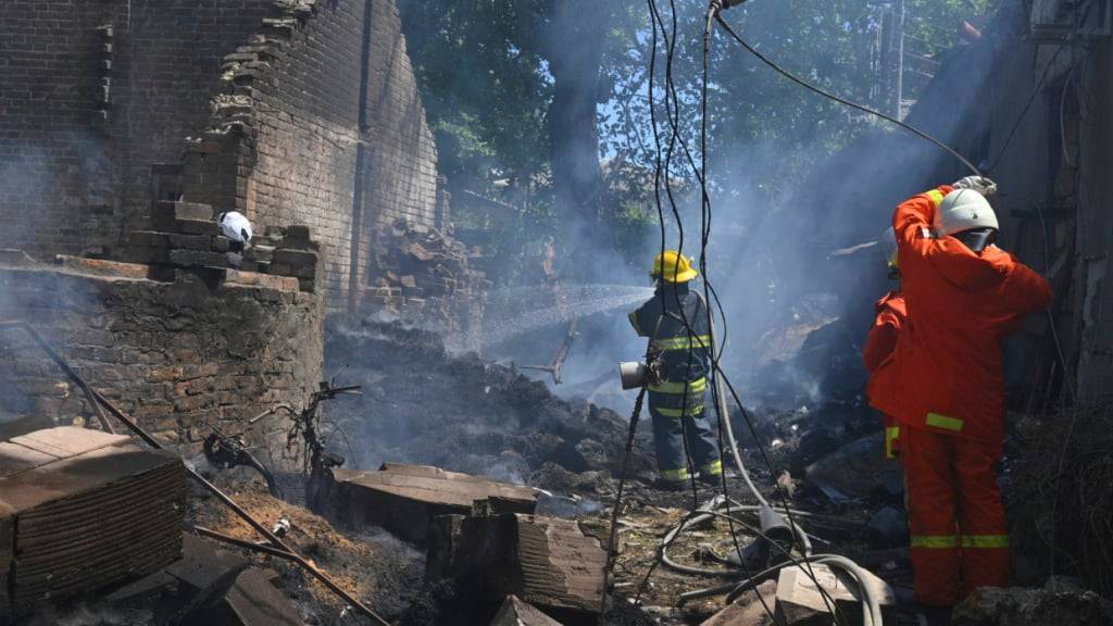 ARCHIV - Feuerwehrleute arbeiten daran, ein Feuer nach einem russischen Angriff zu löschen. Foto: Michael Shtekel/AP/dpa