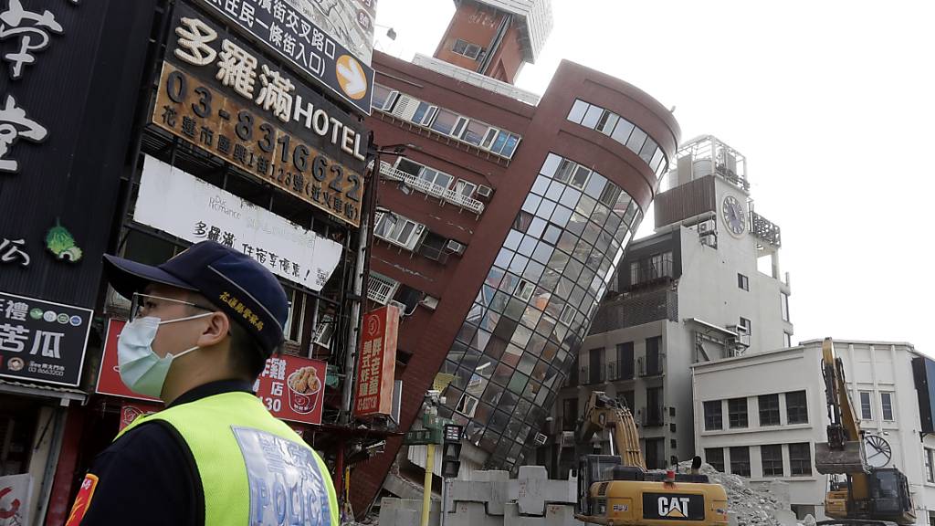 Ein Polizeibeamter steht nach dem Erdbeben in Taiwan neben einem teilweise eingestürzten Gebäude Wache. Foto: ChiangYing-ying/AP