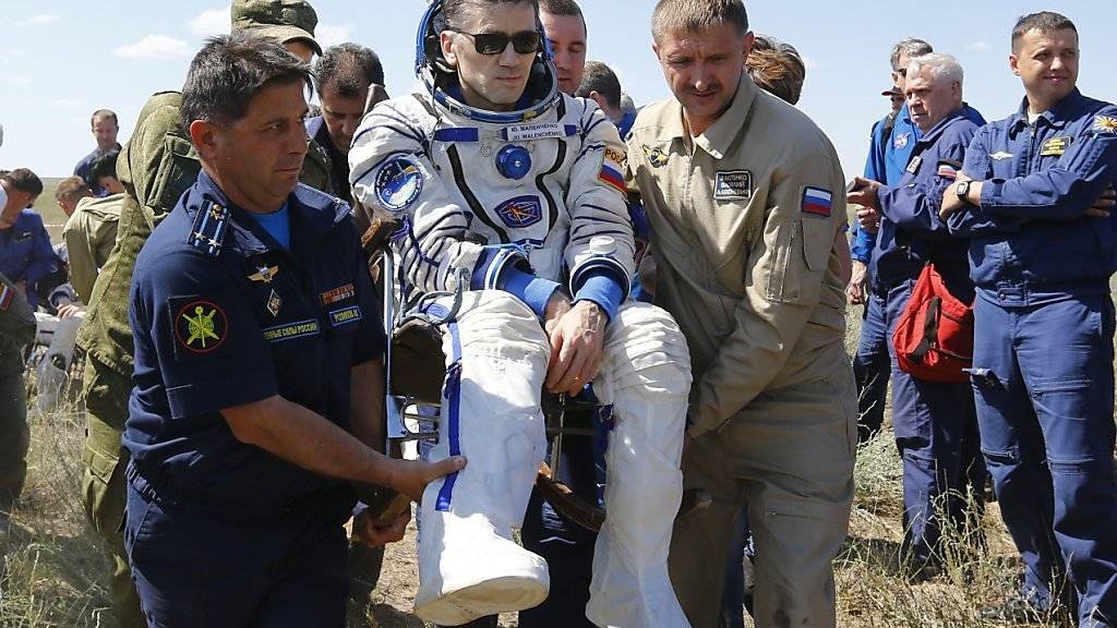 Der russische Kosmonaut Juri Malentschenko lässt sich nach der Landung in Kasachstan feiern.