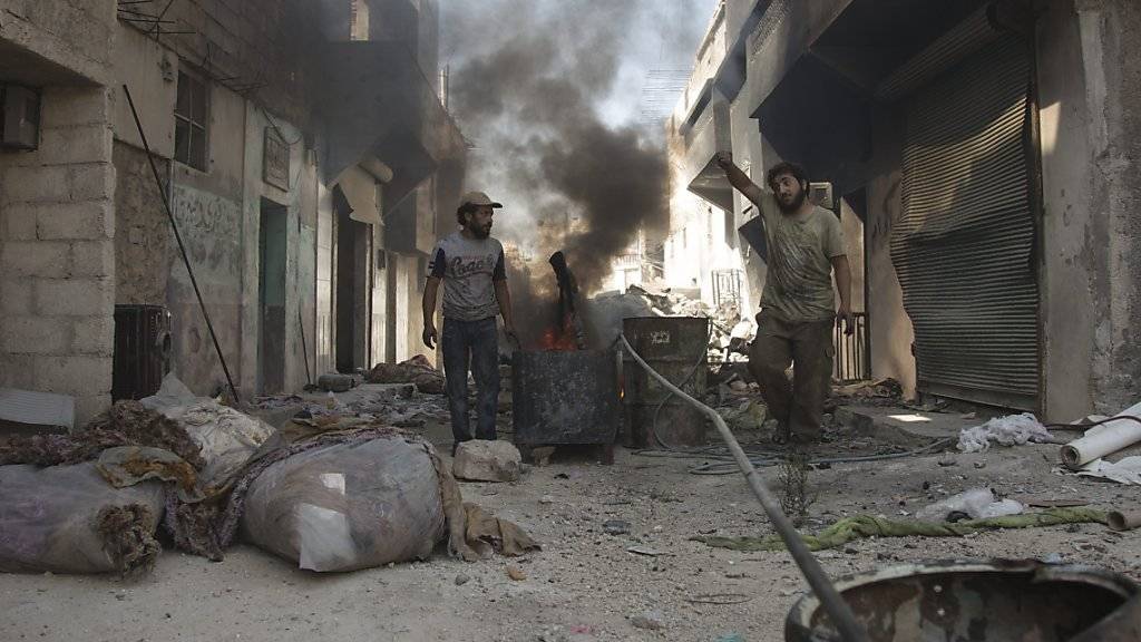 Männer versuchen in den Trümmern Aleppos, Plastik in Treibstoff umzuwandeln. (Archivbild)
