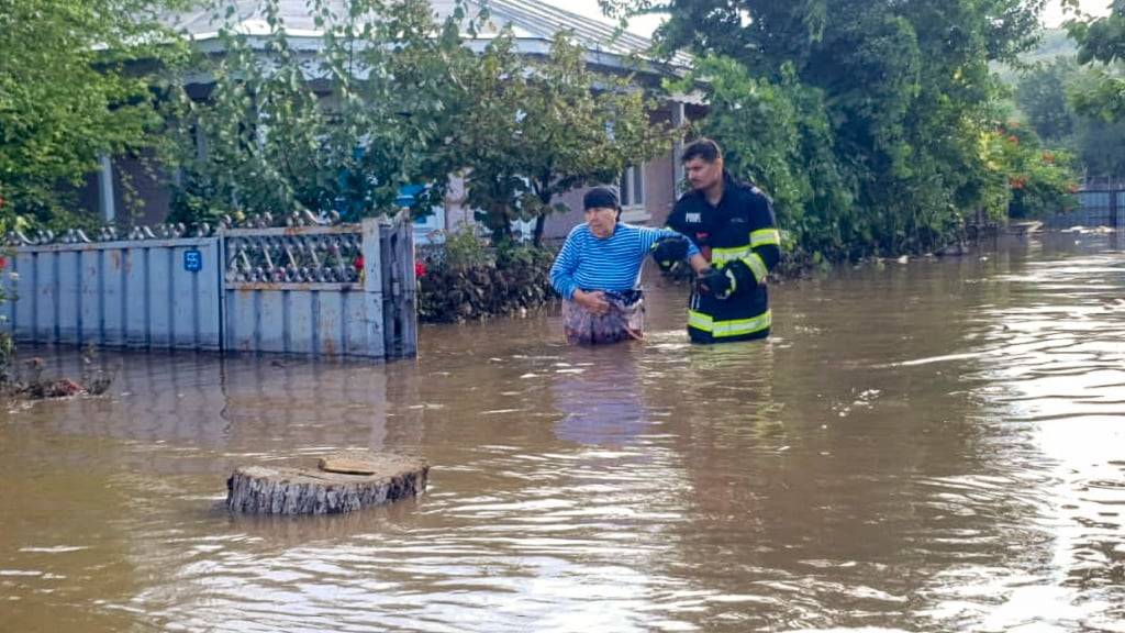 HANDOUT - Auf diesem vom rumänischen Katastrophenschutz Galati (ISU Galati) veröffentlichten Foto hilft ein Retter einer Frau, ein Haus zu verlassen, nachdem sintflutartige Regenfälle zahlreiche Menschen in überschwemmten Gebieten eingeschlossen hatten. Foto: ISU Galati Romanian Emergency Services/AP/dpa - ACHTUNG: Nur zur redaktionellen Verwendung und nur mit vollständiger Nennung des vorstehenden Credits