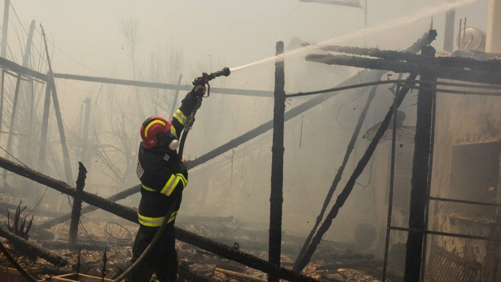 dpatopbilder - Rumänische Feuerwehrleute versuchen in Gennadi, einen Brand zu löschen. Foto: Socrates Baltagiannis/dpa