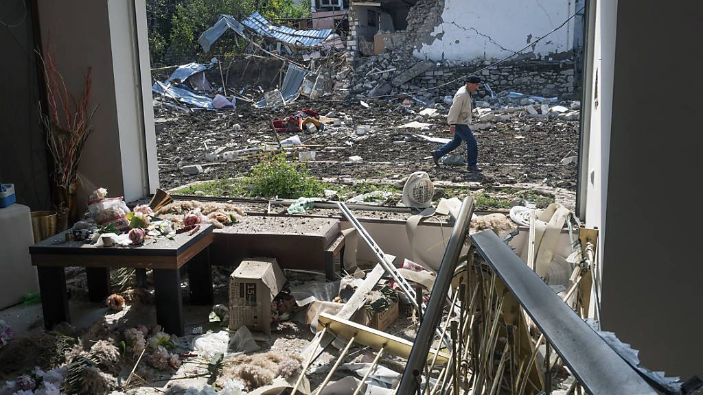 Ein Mann geht an einem Haus vorbei, das von der aserbaidschanischen Artillerie durch Beschuss zerstört wurde. Foto: --/AP/dpa