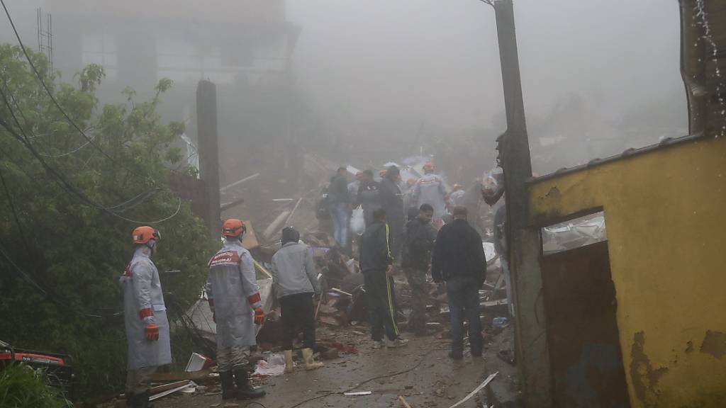 Rettungskräfte suchen in den Trümmern eines nach schweren Regenfällen eingestürzten Hauses  nach Opfern. Foto: Bruna Prado/AP
