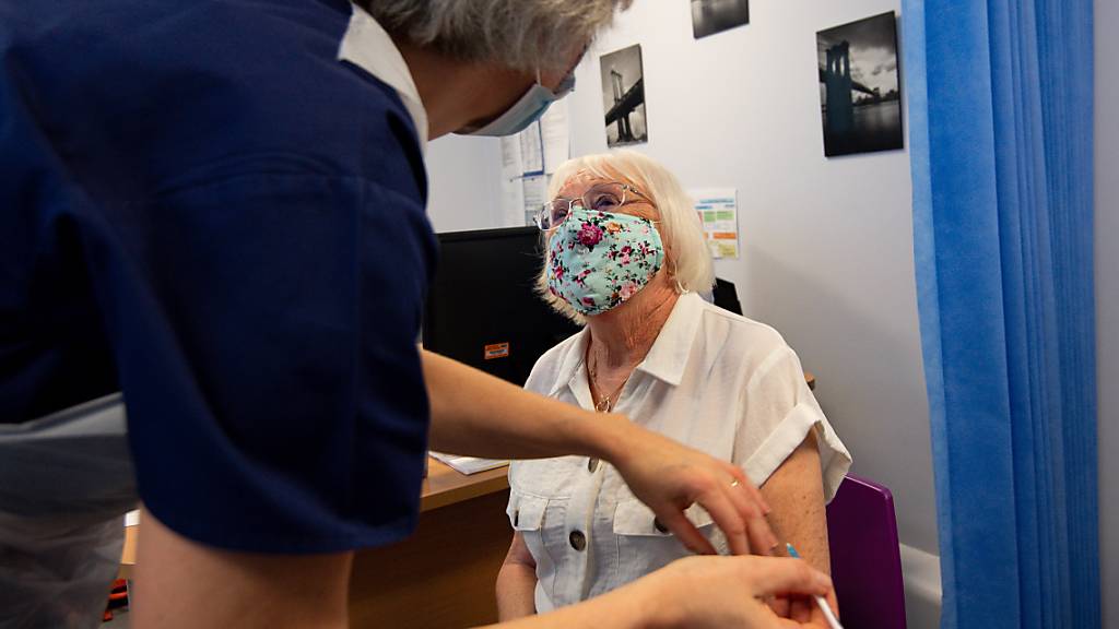 Die 84-jährige Maureen Hughes erhält den Pfizer/Biontech-Impfstoff in der Feldon Lane Surgery. Foto: Jacob King/PA Wire/dpa