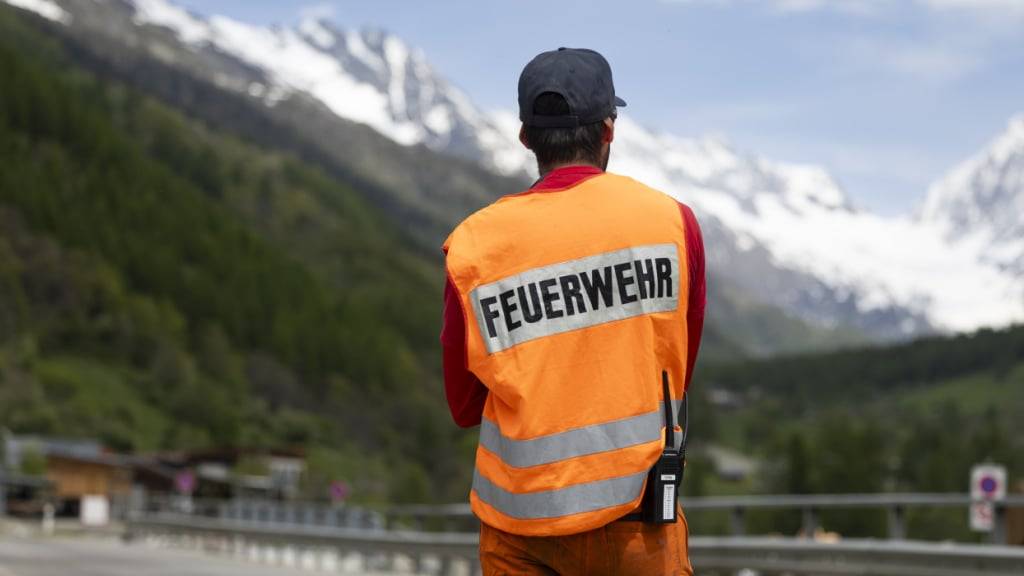Ein Feuerwehrmann sperrt den Verkehr auf einer Strasse in Richtung Blatten im Kanton Wallis. Das Dorf musste wegen der Gefahr eines Bergsturz vor einer Woche evakuiert werden. Nach wie vor ist die Gefahr nicht gebannt.