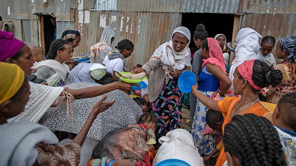 Vertriebene aus der Region Tigray stehen Schlange, um von Anwohnern gespendete Lebensmittel in einem Aufnahmezentrum für Binnenvertriebene zu erhalten. Foto: Ben Curtis/AP/dpa