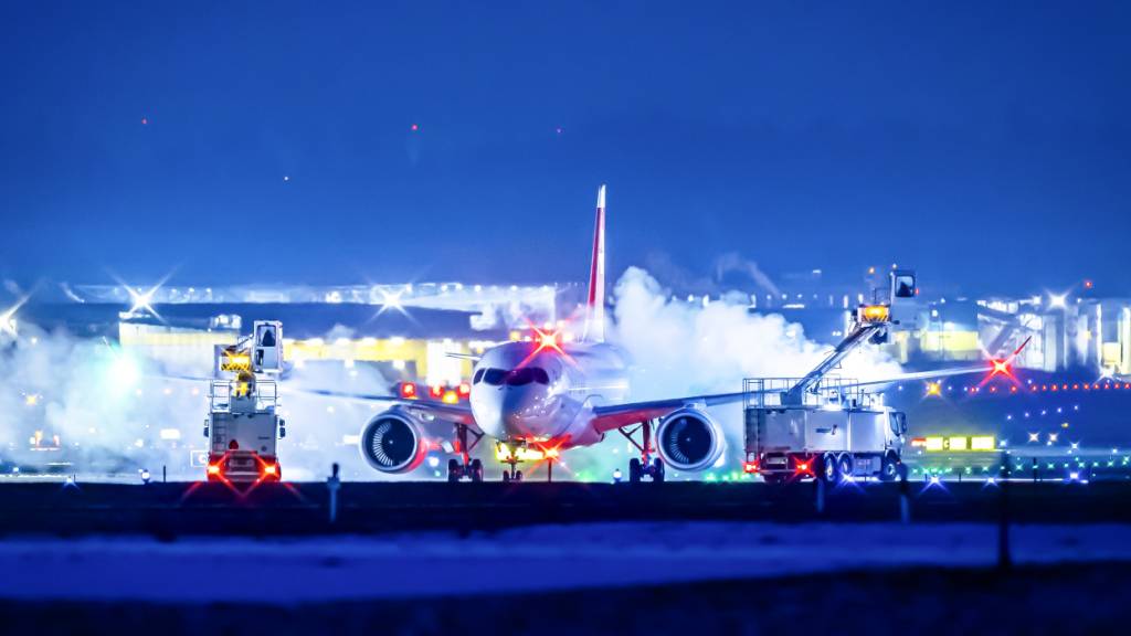 Die Swiss hat wetterbedingt weitere Flüge streichen müssen. (Im Bild: Flugzeug der Swiss bei der Enteisung am Flughafen Zürich-Kloten)