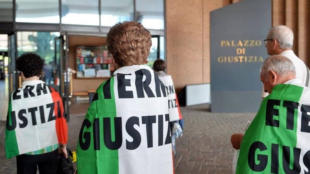Verwandte von Asbest-Opfern, eingehüllt in italienische Flaggen mit dem Schriftzug «Eternit Giustizia» (zu deutsch etwa: «Gerechtigkeit im Eternit-Fall»), vor dem Turiner Justizpalast. (Archiv)