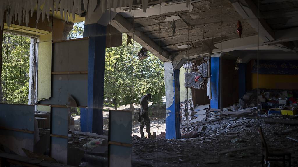 Ein ukrainischer Soldat steht in einem Tanzsaal, der zuvor bombardiert wurde. Foto: Bram Janssen/AP/dpa