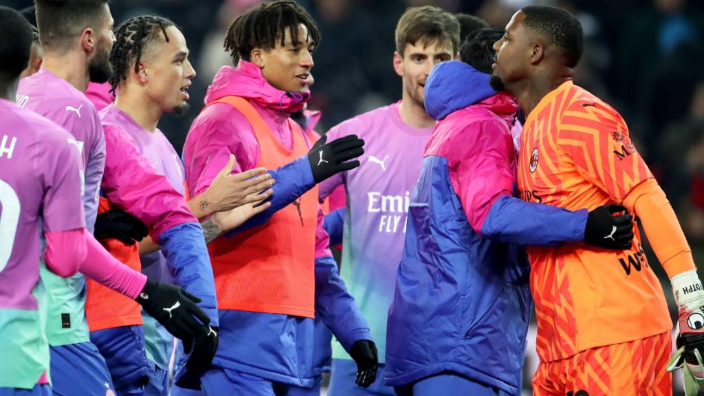 Die Milan-Spieler unterstützen ihren Torhüter Mike Maignan