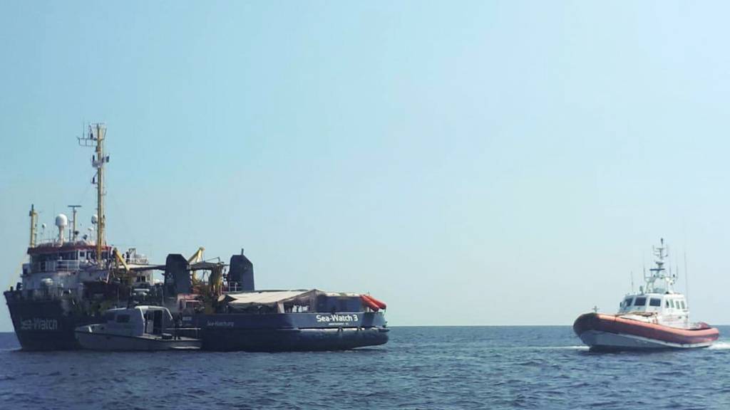 ARCHIV - Ein italienisches Boot der Küstenwache patrouilliert neben dem Rettungsschiff Sea-Watch 3 im Mittelmeer vor der Küste der süditalienischen Insel Lampedusa. Foto: Matteo Guidelli/ANSA/AP/dpa