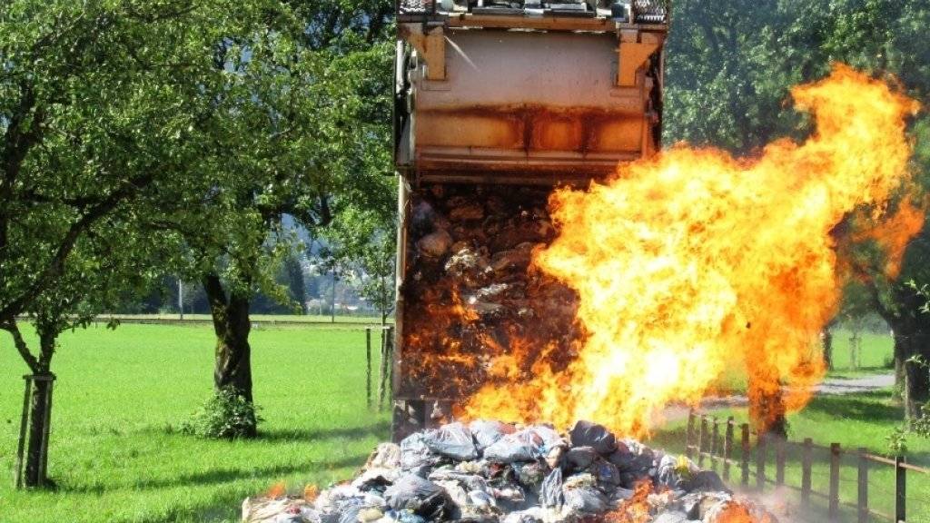 Hier brennen fünf Tonnen Abfall: Um den Kehrrichtwagen zu retten, kippten die Müllmänner den brennenden Abfall auf eine Landstrasse im glarnerischen Näfels.