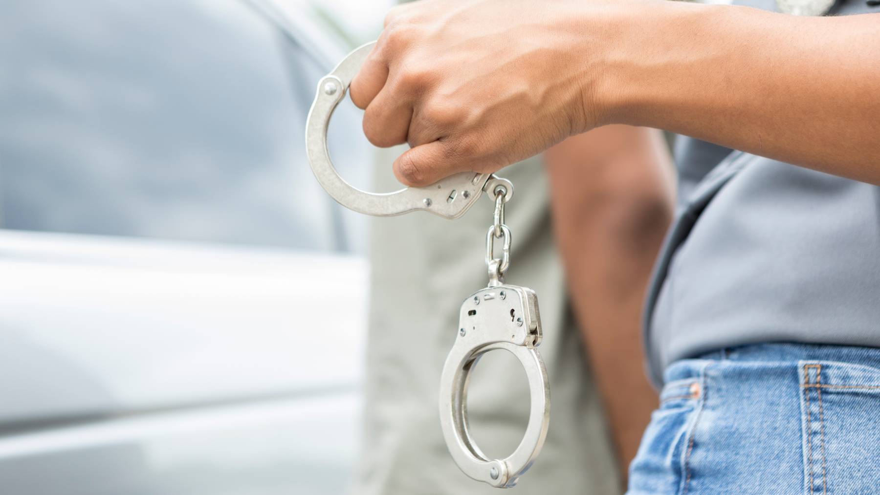 Polizist Verhaftungen Treiber für Verkehrsvergehen Auto Handschellen Symbolbild