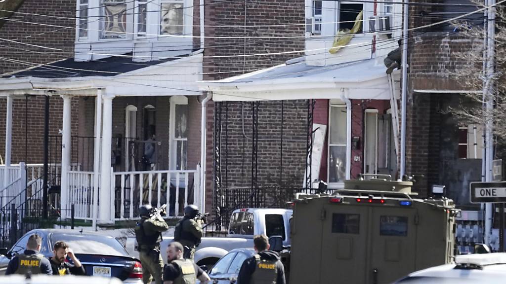 Polizisten umstellen das Haus in Trenton, in dem sich der mutmaßliche Täter mit seinen Geiseln verschanzt hat. Foto: Matt Rourke/AP/dpa