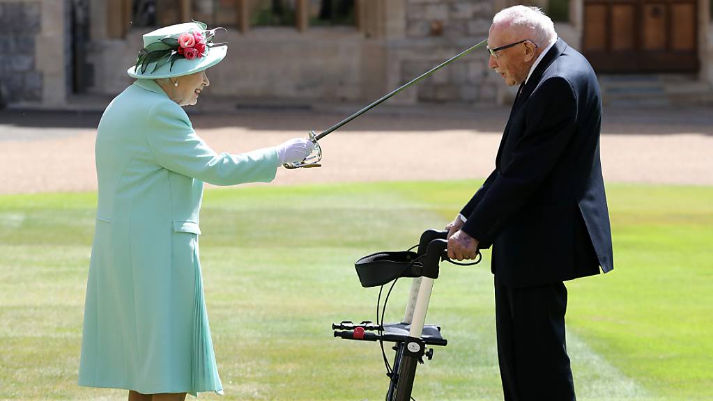 dpatopbilder - Königin Elizabeth II. (l) schlägt Tom Moore (r), Weltkriegsveteran und Rekord-Spendensammler, während einer Zeremonie im Freien auf Schloss Windsor zum Ritter. Foto: Chris Jackson/PA Wire/dpa