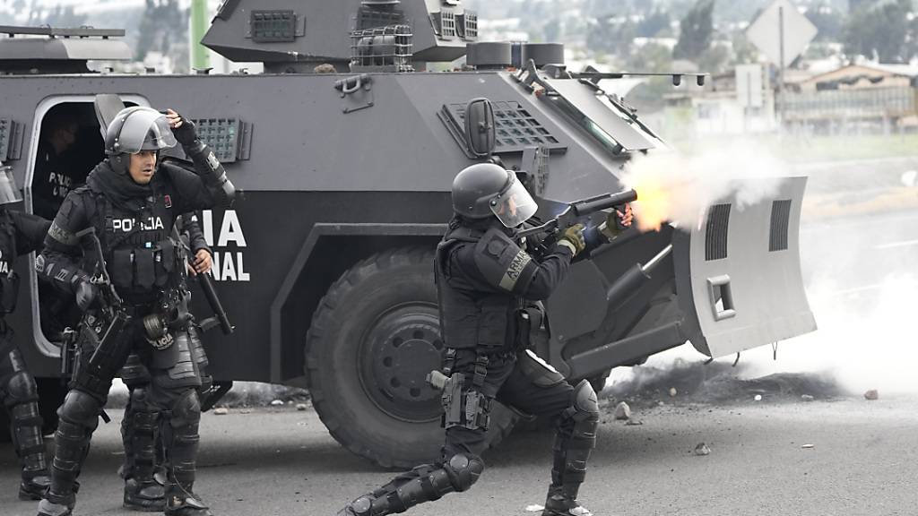 Ein ecuadorianischer Polizist feuert Tränengas auf Demonstranten ab. Foto: Dolores Ochoa/AP/dpa