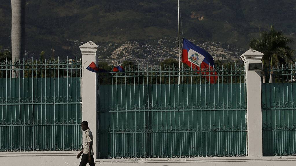 dpatopbilder - Die haitianische Flagge weht auf Halbmast vor dem Präsidentenpalast in Port-au-Prince, drei Tage nachdem Präsident Jovenel Moise in seinem Haus ermordet wurde. Foto: Fernando Llano/AP/dpa