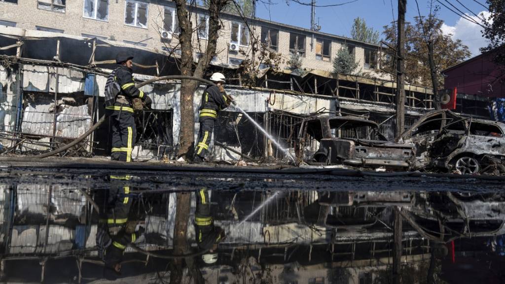 Nach dem Beschuss eines Marktplatzes in der ostukrainischen Stadt Kostjantyniwka löschen Rettungskräfte ein Feuer. Foto: Evgeniy Maloletka/AP/dpa