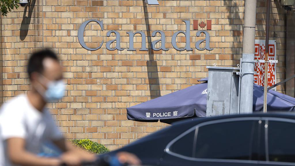 Ein Mann fährt auf einem Motorroller über eine Kreuzung in der Nähe der kanadischen Botschaft in Peking. Ein chinesisches Gericht hat vor dem Hintergrund der diplomatischen Spannungen zwischen China und Kanada das Todesurteil gegen einen kanadischen Drogenhändler bestätigt. Foto: Mark Schiefelbein/AP/dpa
