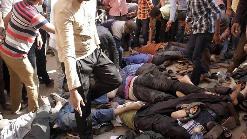 Teilnehmende einer Trauerfeier in Bangladesch suchen nach Angehörigen, die bei einer Massenpanik zu Tode getrampelt wurden.