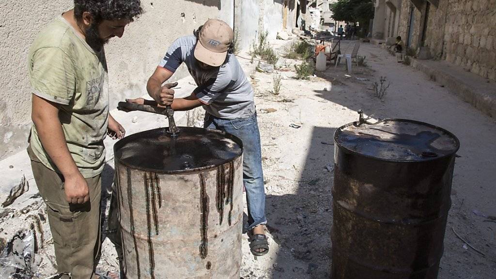 Seit Montagabend hält eine Waffenruhe in Syrien. Für die Menschen fehlt es an allem. In den von Rebellen gehaltenen und von Regierungstruppen belagerten Vierteln von Aleppo stellen Männer aus Plastik Treibstoff für Generatoren her. (Bild vom 9. September)