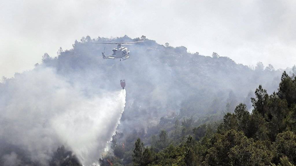Ein Helikopter versucht einen Waldbrand im Osten Spaniens zu löschen.