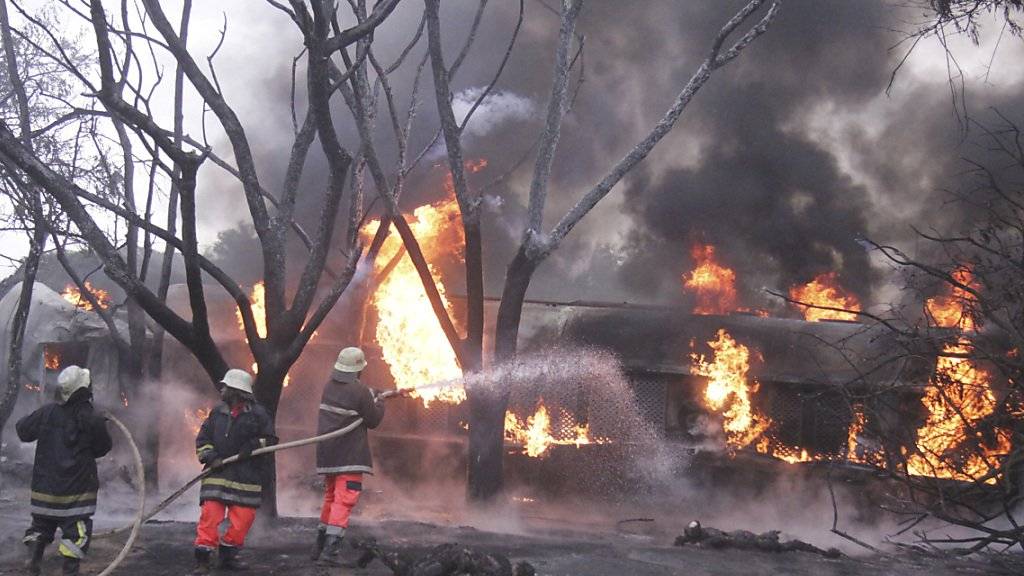 Nach der Explosion eines Tanklastwagens bekämpfen Feuerwehrleute den Brand.