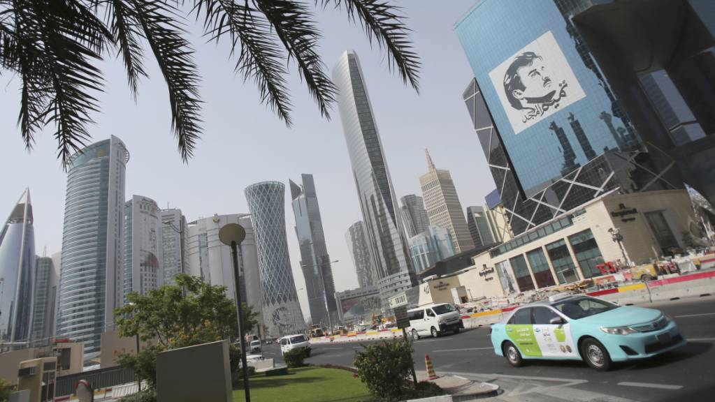 ARCHIV - Ein Taxi fährt an einem Gebäude mit einem Bild des Emirs von Katar, Sheikh Tamim bin Hamad Al Thani, vorbei. Mehr als drei Jahre nach dem Beginn einer Blockade gegen Katar legen Saudi-Arabien und seine Verbündeten ihren Streit mit dem Emirat bei. Foto: Kamran Jebreili/AP/dpa