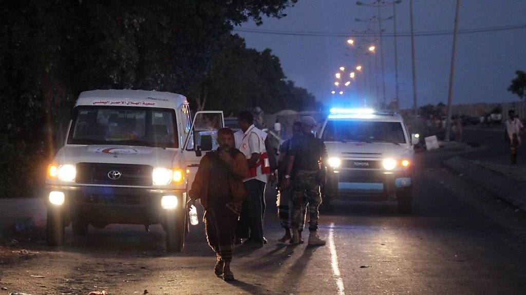 Vertreter der Hilfsorganisation Roter Halbmond und Sicherheitsleute am Ort des Anschlags in Aden.
