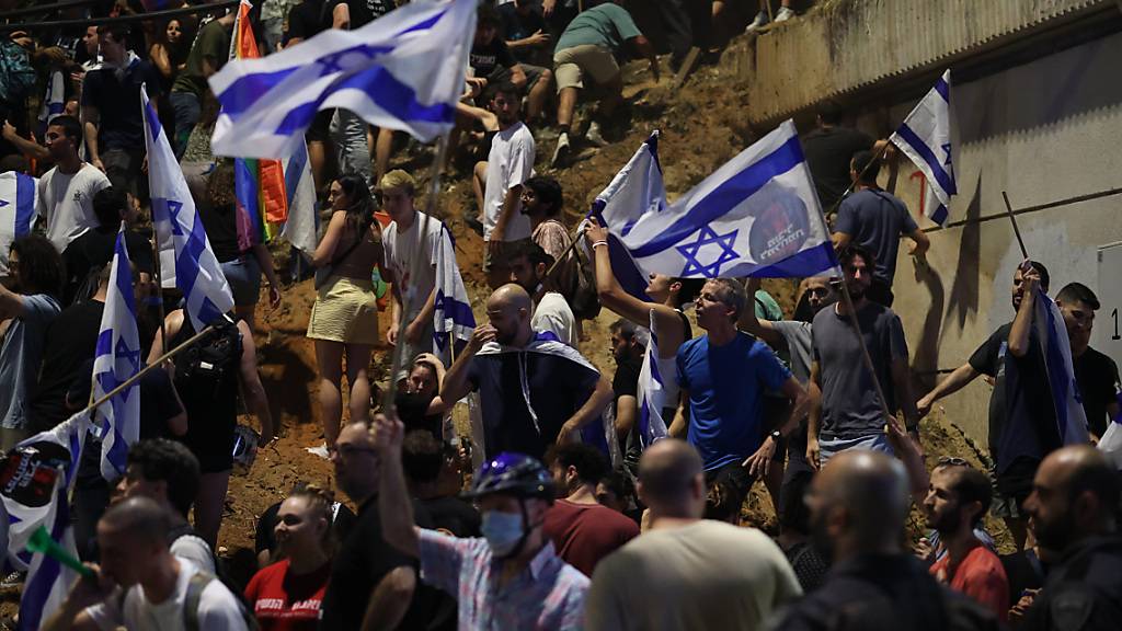 Israelische Demonstranten schwenken Fahnen während eines Protestes gegen die umstrittene Justizreform. Foto: Ilia Yefimovich/dpa