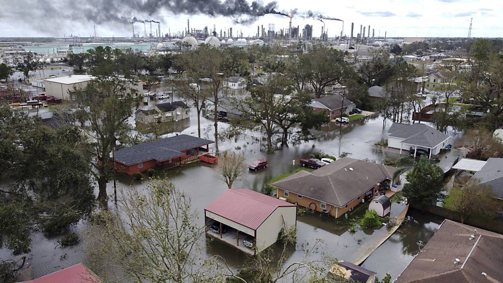Hochwasser steht in einer Wohnsiedlung und auf dem Gelände einer Raffinerie bei Norco, Louisiana, in der am Morgen nach dem Hurrikan Ida Gase kontrolliert abgefackelt werden.