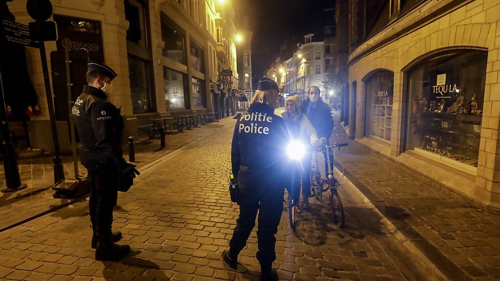 Zwei Polizeibeamte patrouillieren zu Beginn der Ausgangssperre durch die Stadt. Die belgische Regierung führte strengere Maßnahmen ein, um das Risiko der Ausbreitung von Covid-19 zu verringern, da die Zahl der Covid-19-Infektionen stark ansteigt. Foto: Thierry Roge/BELGA/dpa