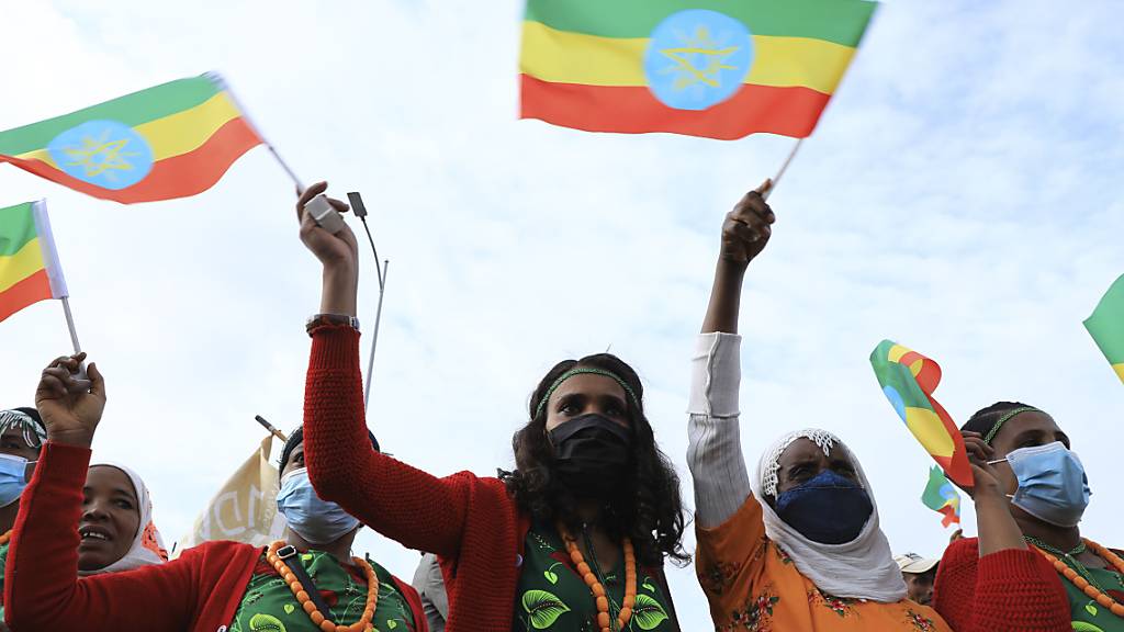 Demonstranten in Addis Abeba schwenken Flaggen, um unter dem Motto «Ich marschiere, um Äthiopien zu retten» gegen die Partei Volksbefreiungsfront von Tigray (TPLF) zu demonstrieren. Die TPLF hat am Sonntag erstmals bestätigt, dass ihre Kämpfer die historische Stadt Lalibela unter Kontrolle haben. Foto: Stringer/AP/dpa