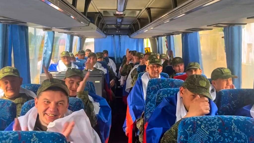 HANDOUT - Auf diesem vom Pressedienst des russischen Verteidigungsministeriums veröffentlichten Video sitzen russische Soldaten mit russischen Nationalflaggen in einem Bus, nachdem sie im Rahmen eines  Kriegsgefangenenaustauschs zwischen Russland und Ukraine aus der Gefangenschaft zurückgekehrt sind. Foto: Uncredited/Russian Defense Ministry Press S/dpa