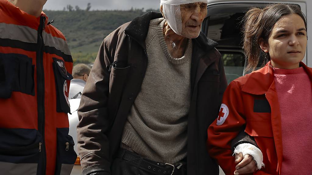 Ein verwundeter armenischer Mann wird von Freiwilligen bei seiner Ankunft in der armenischen Stadt Goris in der Region Syunik, Armenien gestützt. Foto: Vasily Krestyaninov/AP/dpa