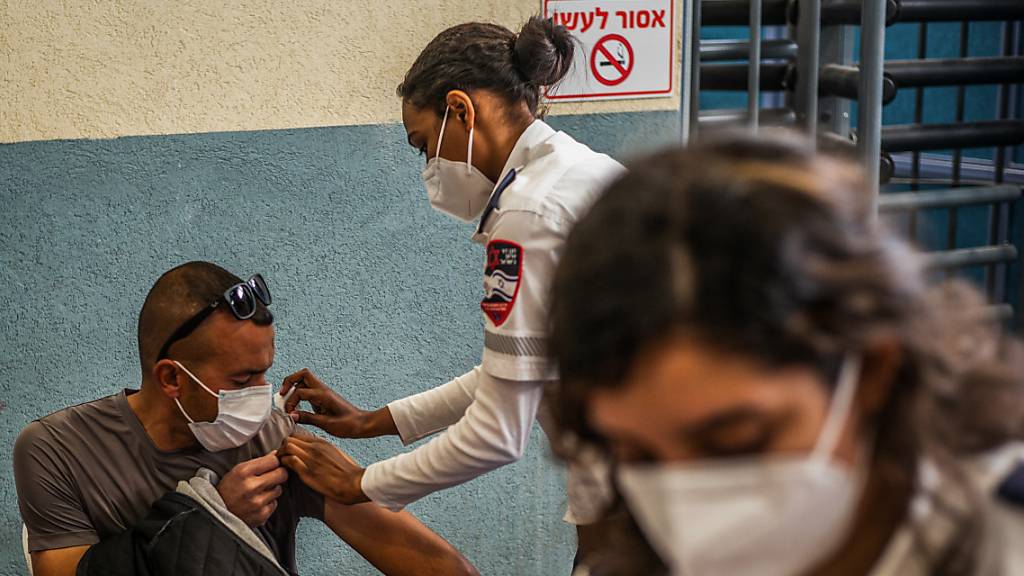 Eine medizinische Angestellte verabreicht einem palästinensischer Grenzgänger eine Corona-Schutzimpfung. Am Grenzübergang von Meitar wurde eine Impfzentrum errichtet. Foto: Ilia Yefimovich/dpa