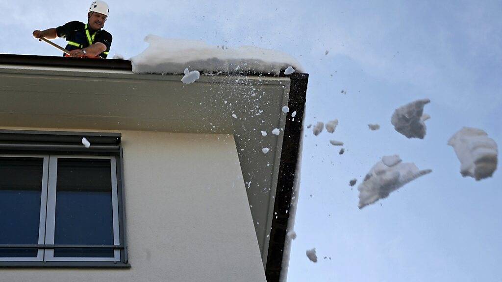 Hauseigentümer sind verpflichtet, Dachlawinen zu verhindern. Im Bild ein gesicherter Feuerwehrmann im März 2006 in Zürich. (Archivbild)