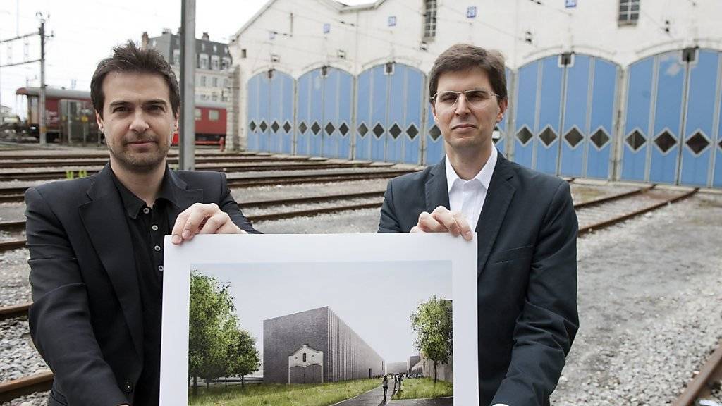 Die Architekten Alberto Veiga (rechts) und Fabrizio Barozzi zeigen ein Foto ihres Projekts «Bleu» am Ort, wo das neue Kunstmuseum enstehen soll (Archiv).